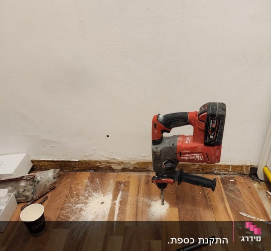 מקדחה על רצפה עם שבבי עץ